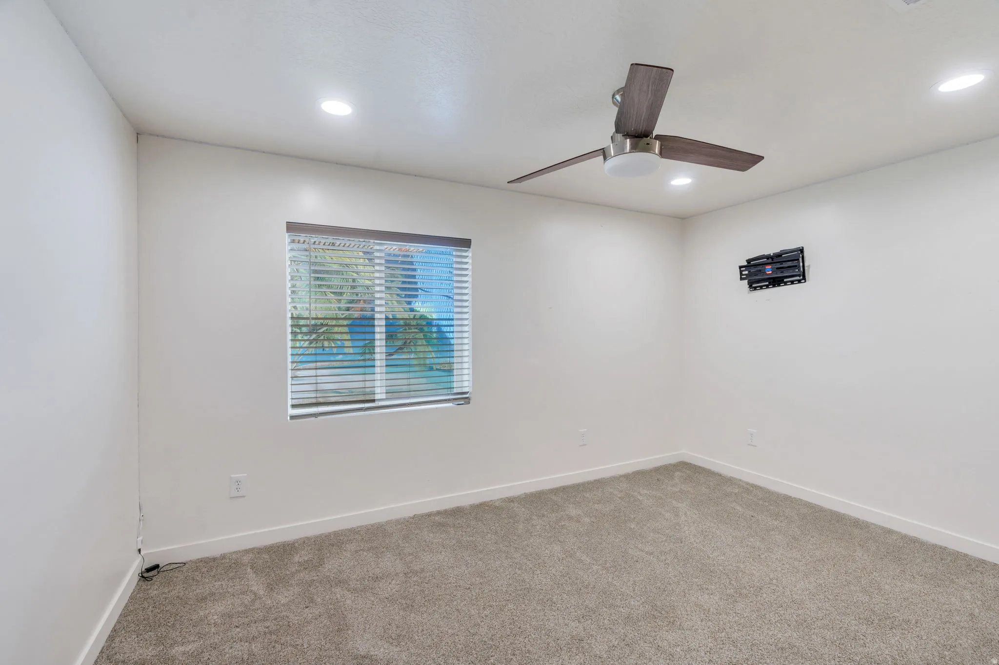 Neutral-toned room featuring a window with blinds, recessed lighting, and a ceiling fan with light