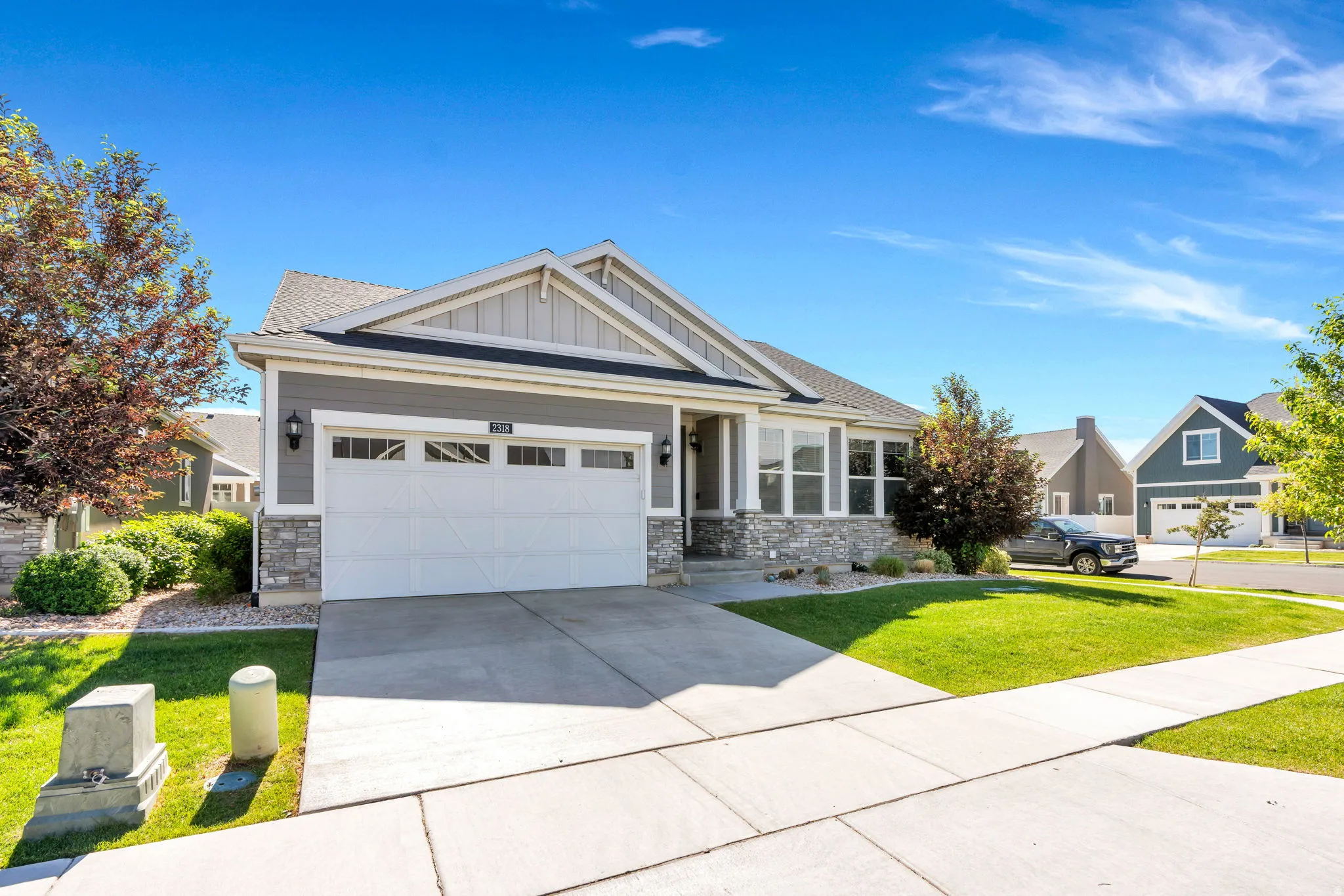 Contemporary ranch-style residence featuring a combination of gray siding and stone veneer
