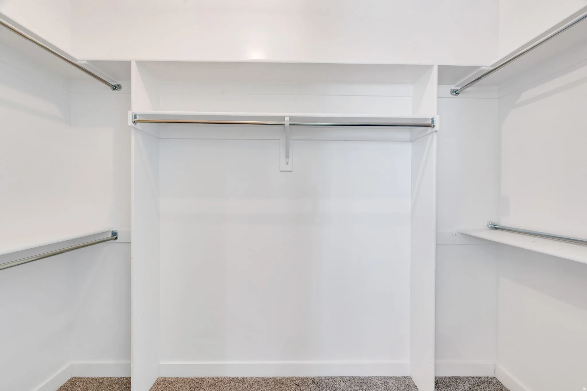 White closet system featuring multiple hanging rods and integrated shelving