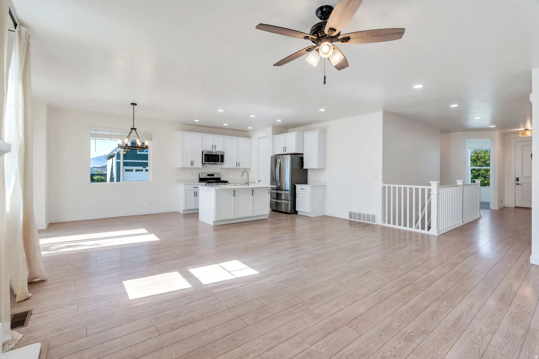 Light wood-finish flooring spanning an open-concept living space with a kitchen island