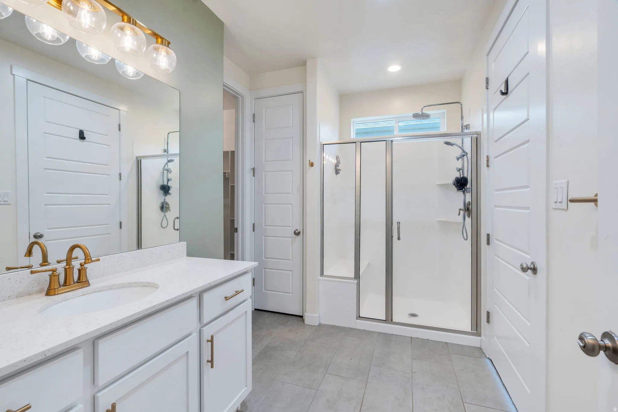 Modern bathroom vanity with a white countertop and gold-finish faucet