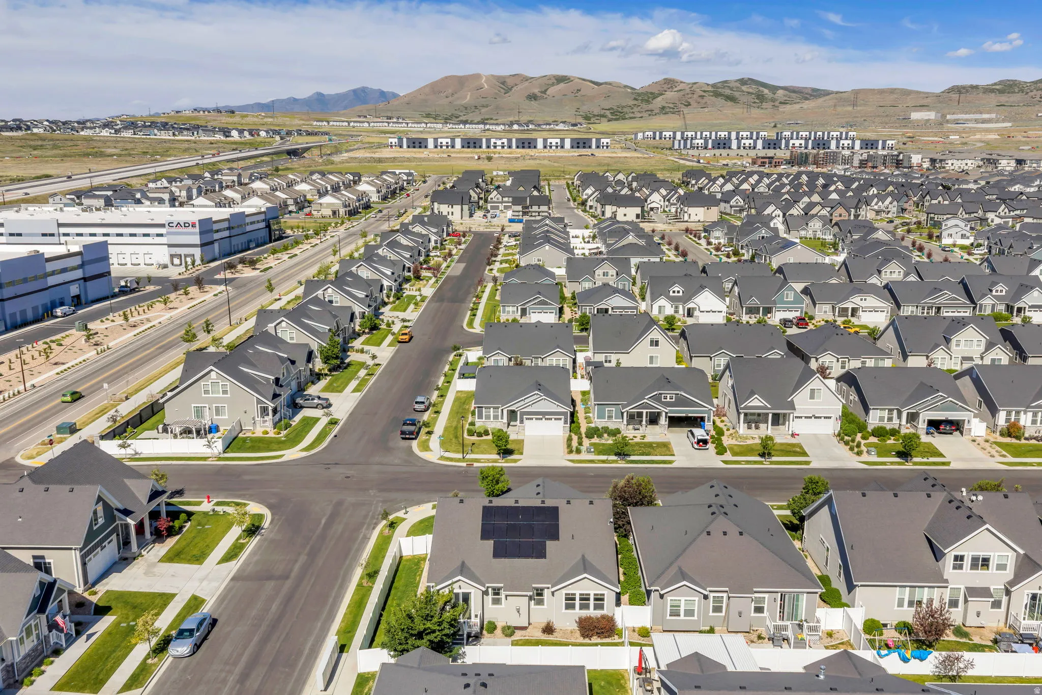 Expansive neighborhood featuring numerous single-story and two-story residences with diverse architectural styles, gray shingle roofing, and attached garages
