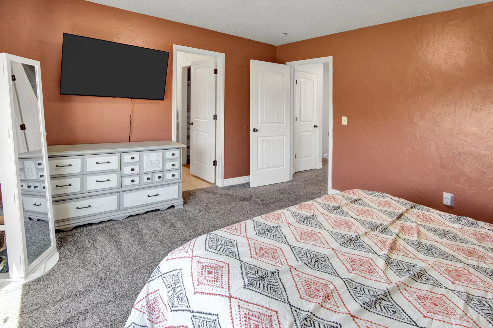 Carpeted room featuring warm-toned walls, white trim, and two white paneled doors