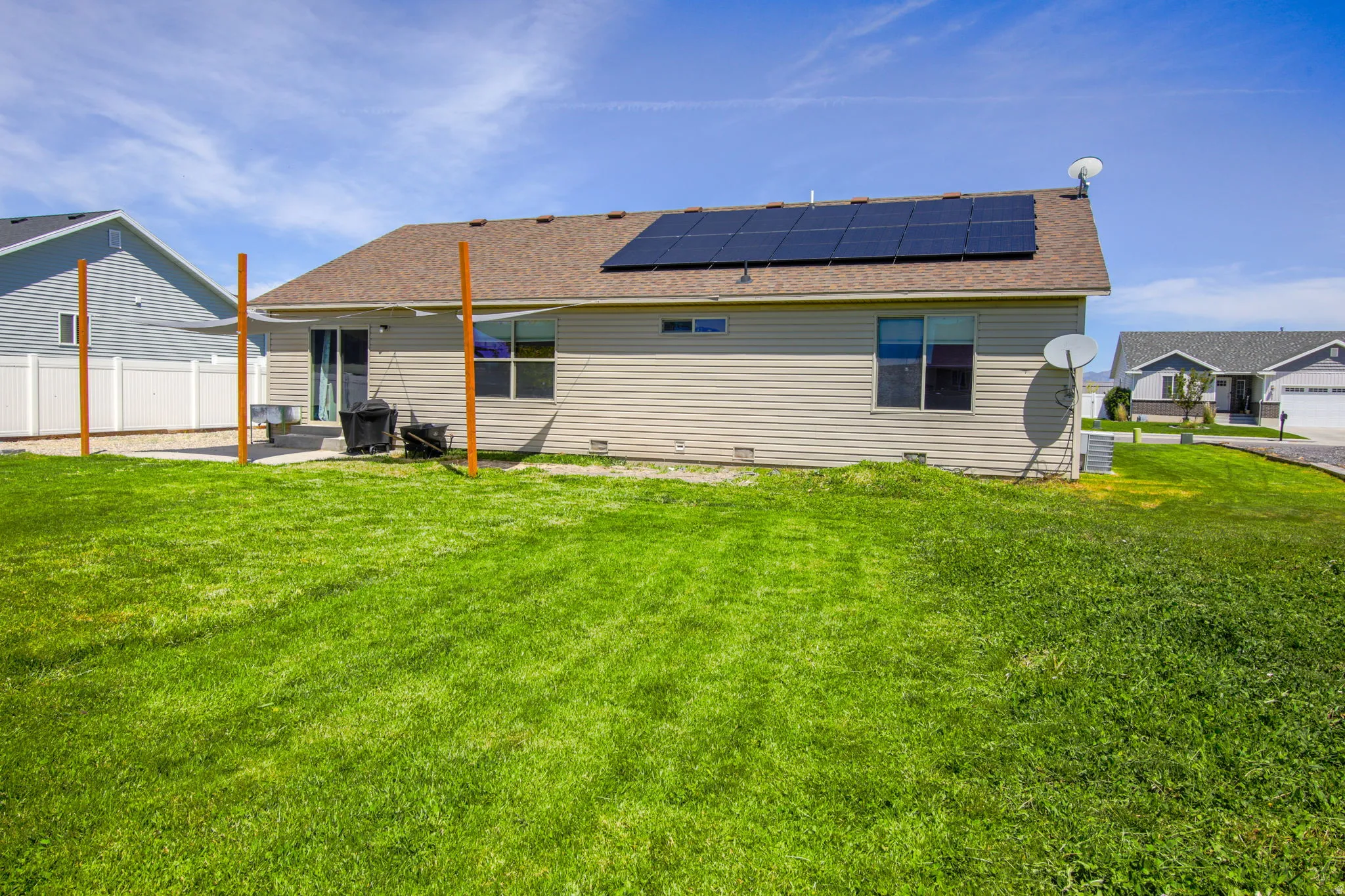 Expansive backyard featuring a lush lawn, a patio area, and a privacy fence