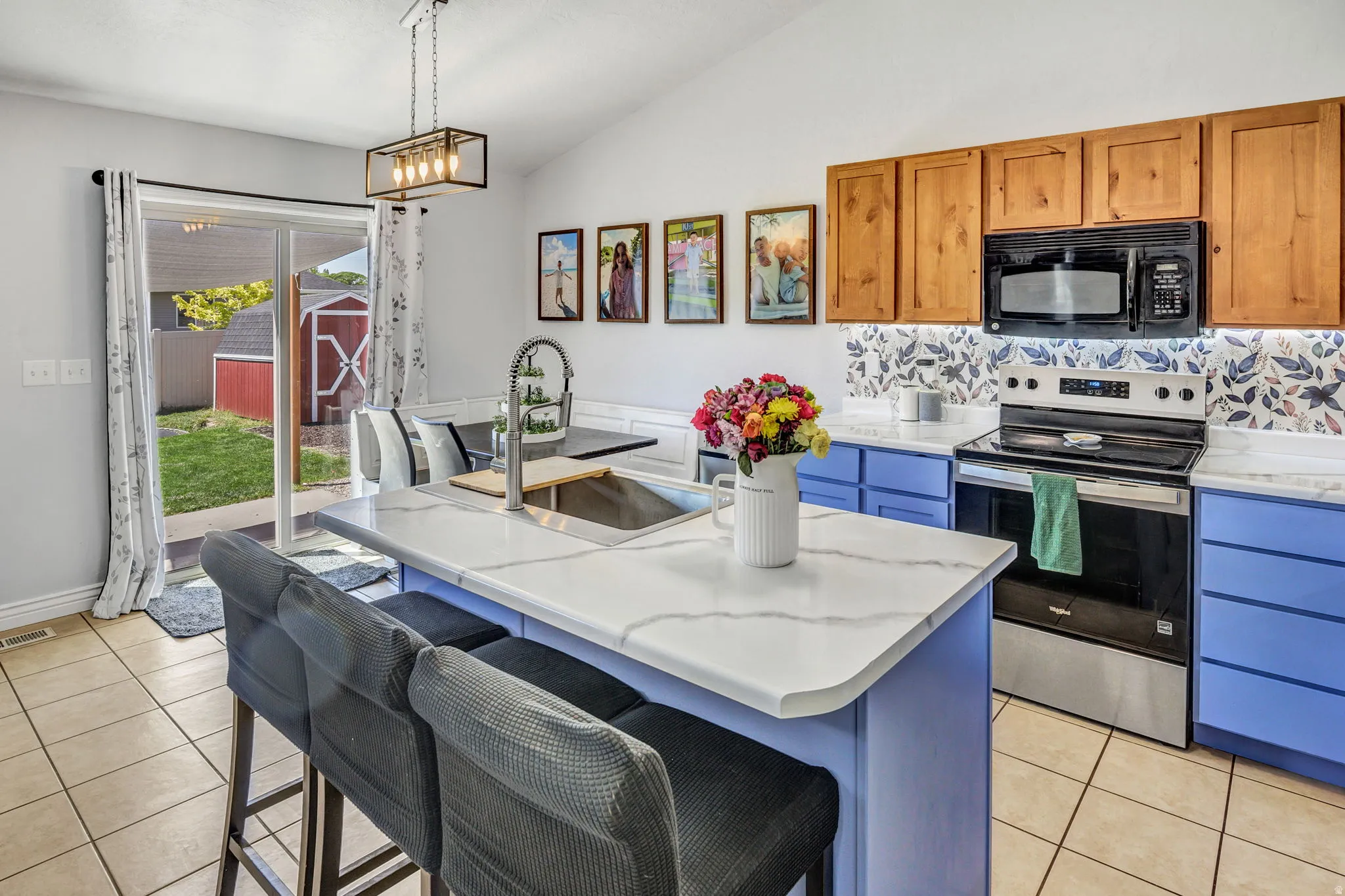 Kitchen with a central island featuring a stainless steel sink and a white countertop