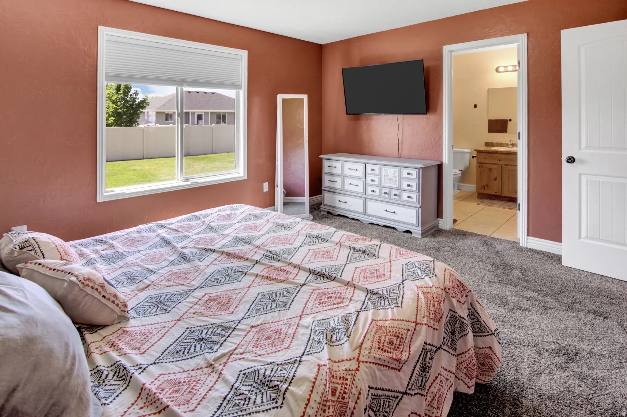 Carpeted bedroom with textured walls and a bright window