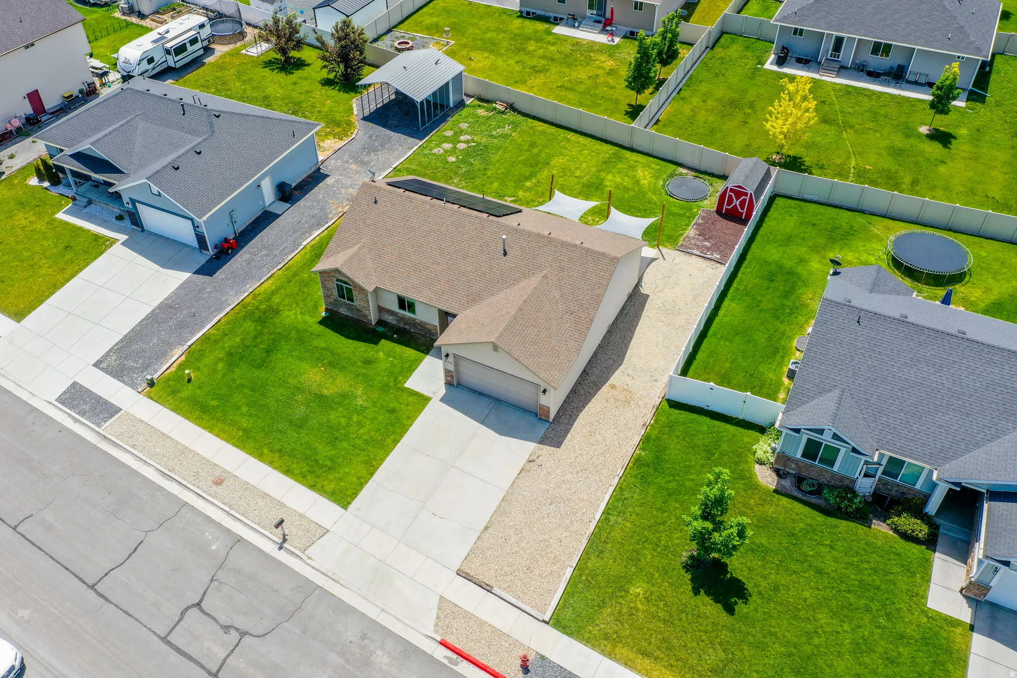 Single-story residence featuring a two-car garage and a gravel side yard