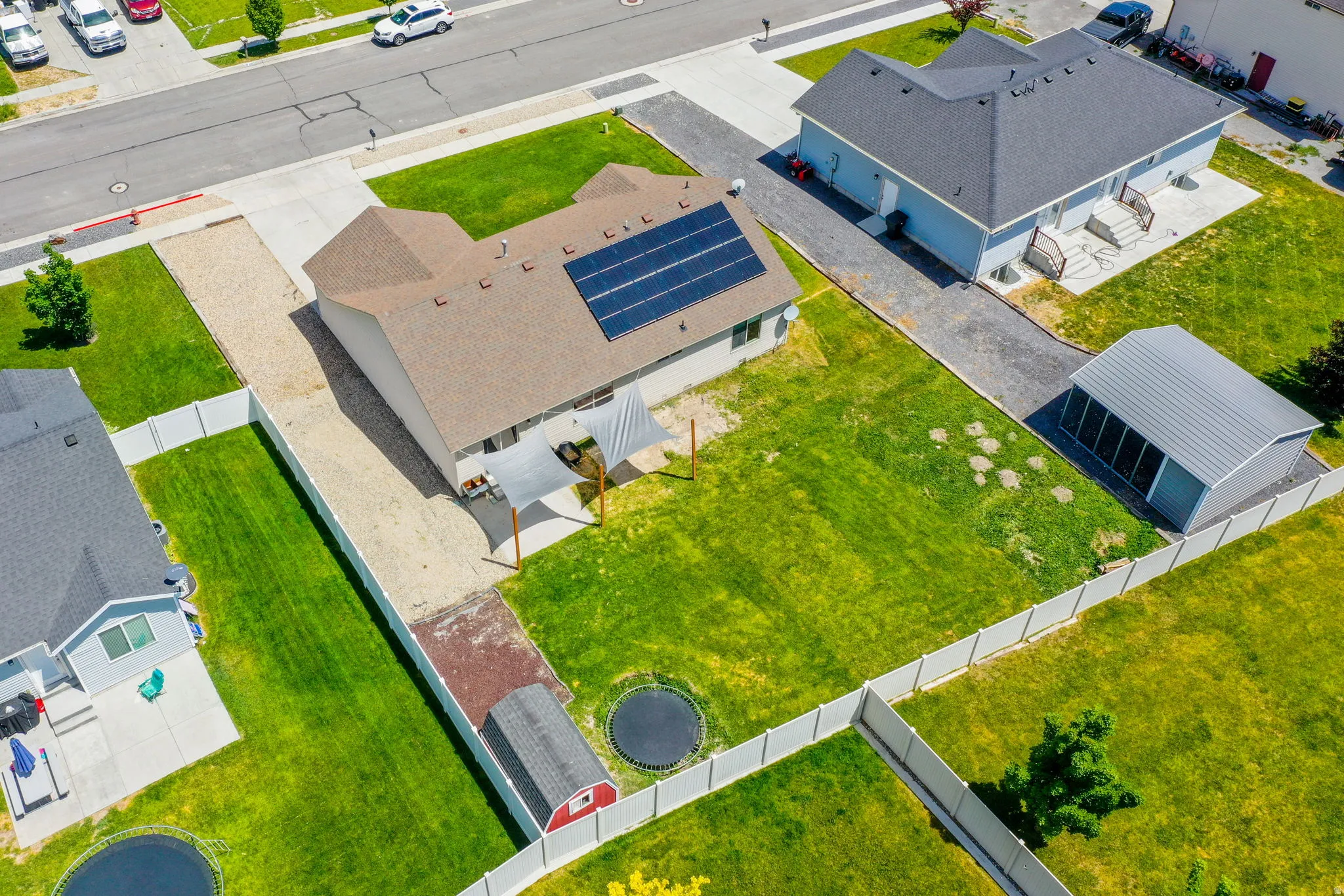 Expansive green lawn with a white privacy fence