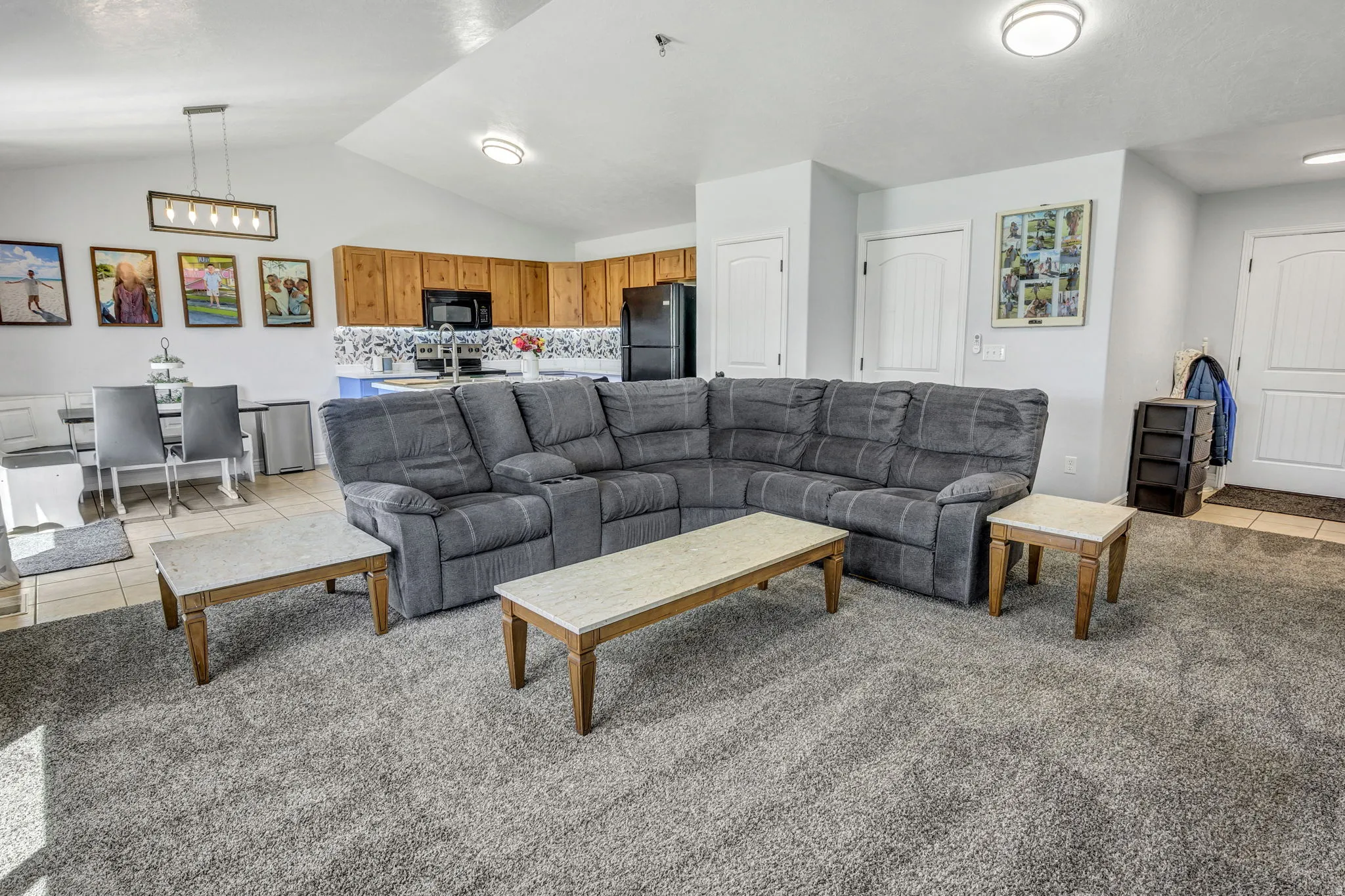Open-concept living space featuring a vaulted ceiling and recessed lighting