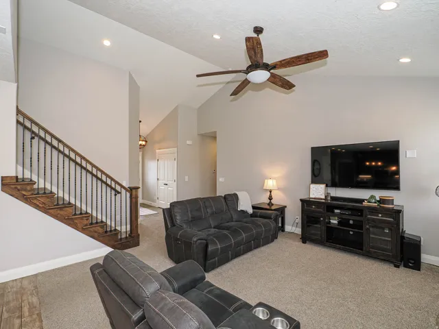 Living area featuring vaulted ceilings, recessed lighting, and a ceiling fan