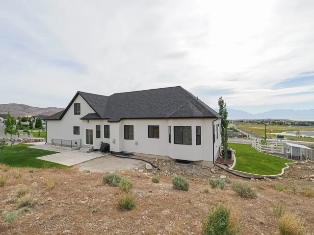 Contemporary exterior with white stucco finish and dark shingle roof