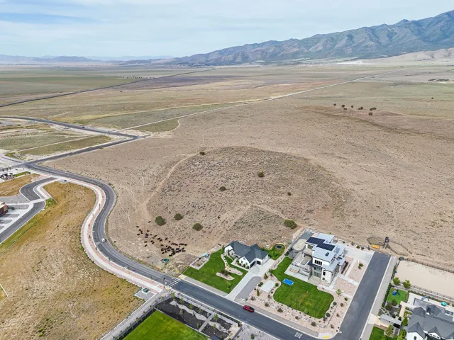 Expansive aerial perspective showcasing a substantial undeveloped land parcel with a mountainous backdrop