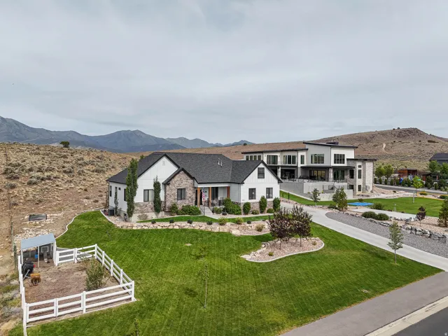 Modern farmhouse exterior with board and batten siding, stone accents, dark-framed windows, and a dark shingle roof