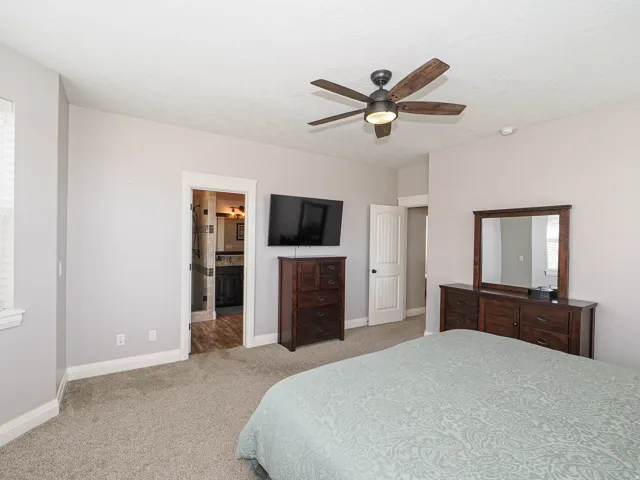 Carpeted bedroom with a ceiling fan, recessed lighting, and a window featuring blinds