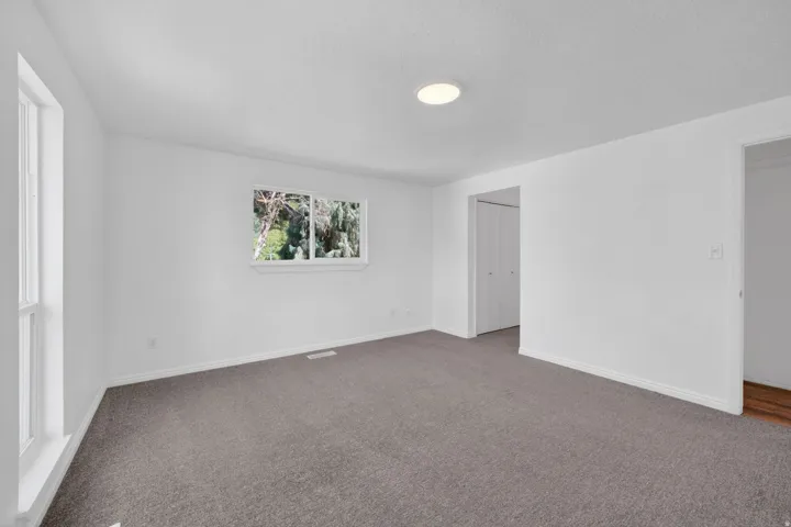 White-painted interior room with grey carpet flooring
