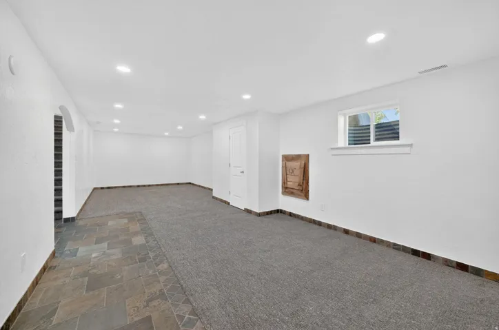 Spacious room featuring mixed flooring with large format tiles and carpeting