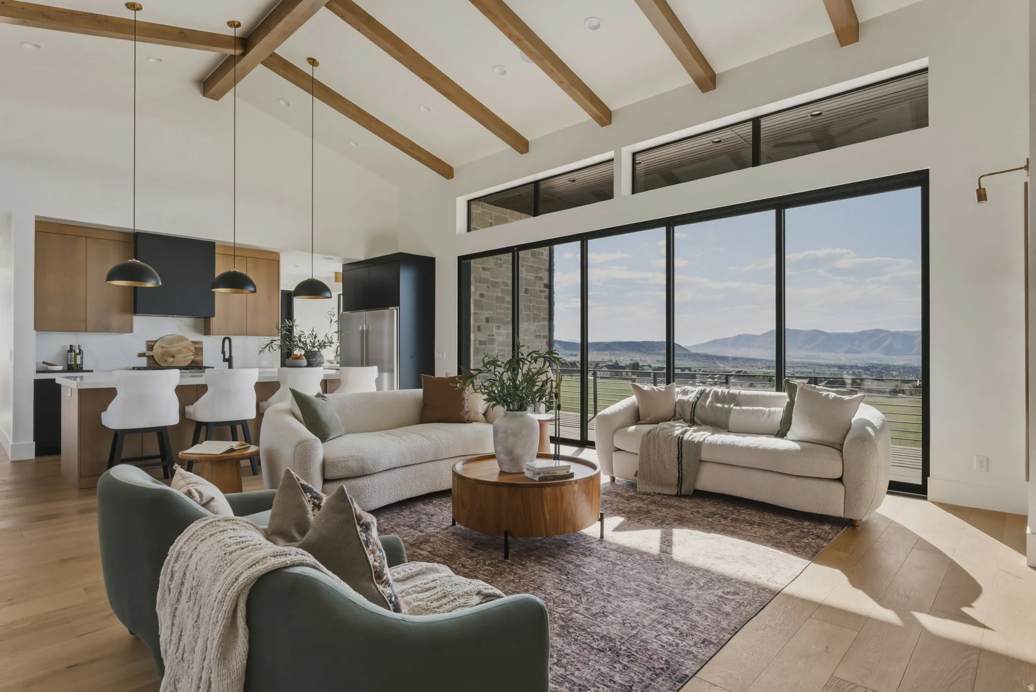 Open-concept living space featuring vaulted ceilings with exposed wood beams, a full wall of floor-to-ceiling windows, and light wood-finish flooring