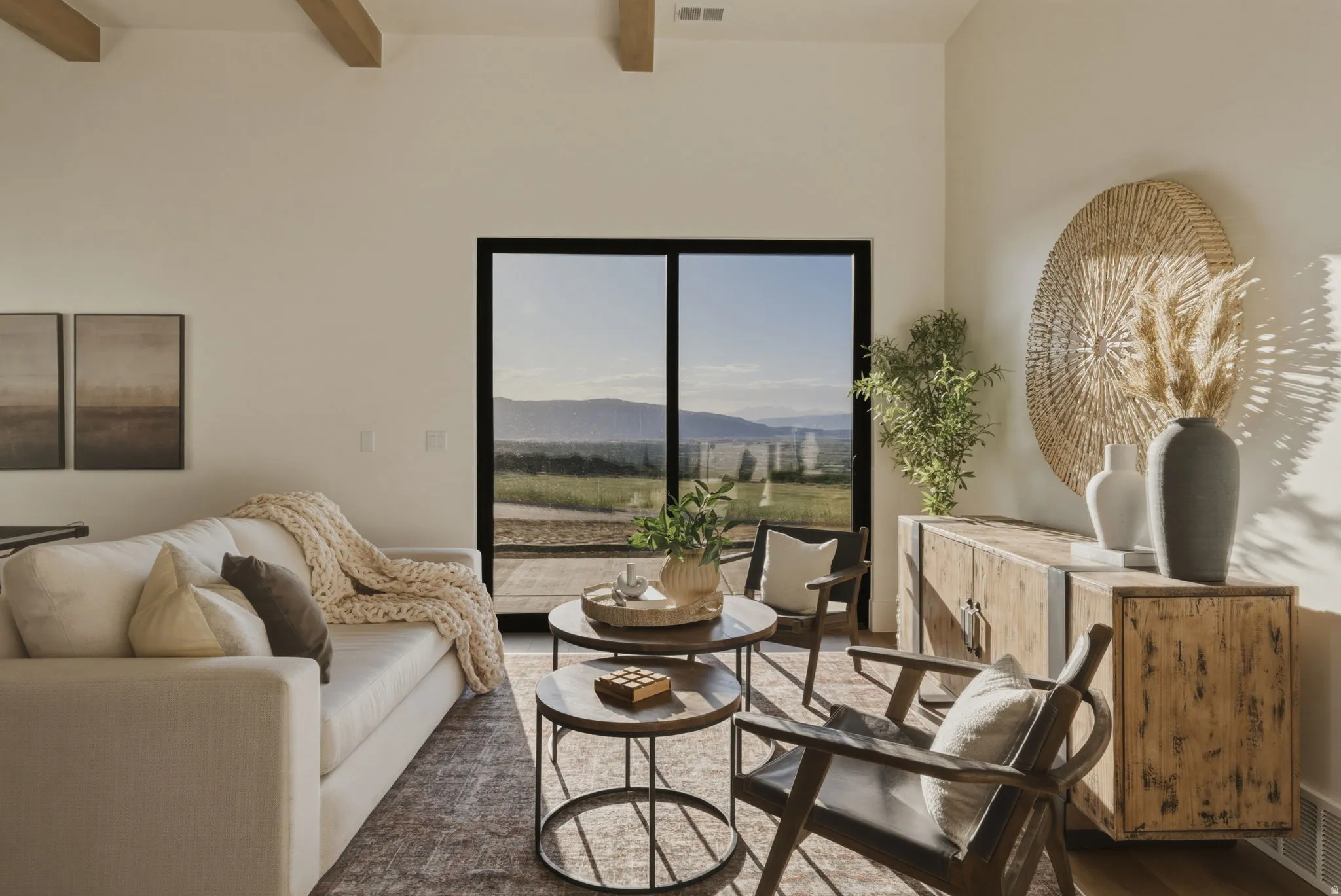 Living area with exposed beam ceiling and expansive sliding glass doors