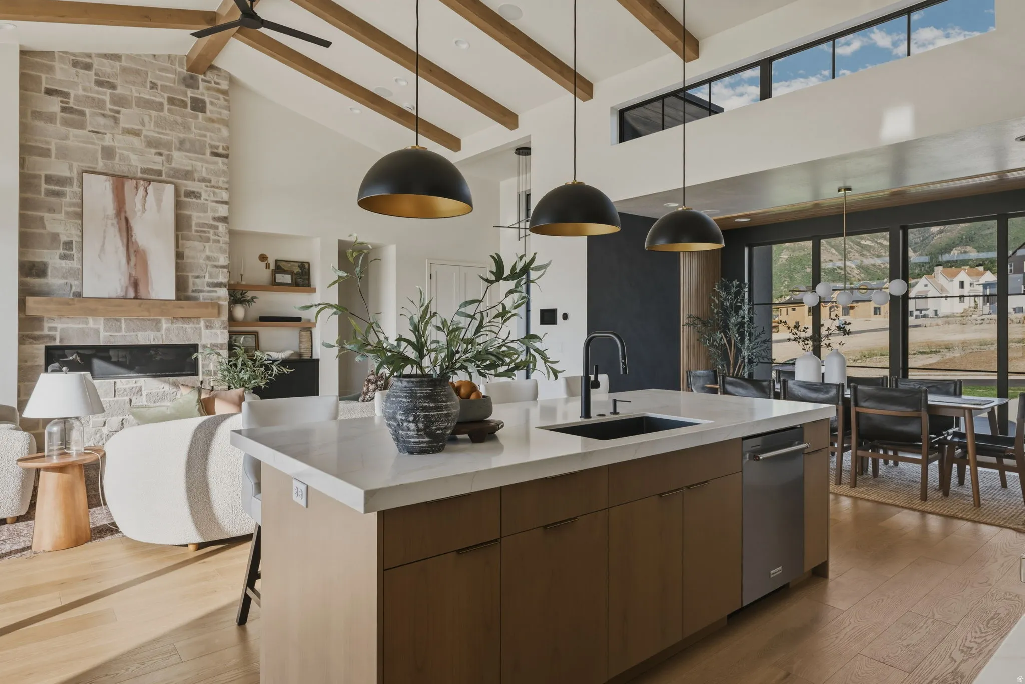 Open-concept living area featuring a large kitchen island with a built-in sink and stainless steel dishwasher