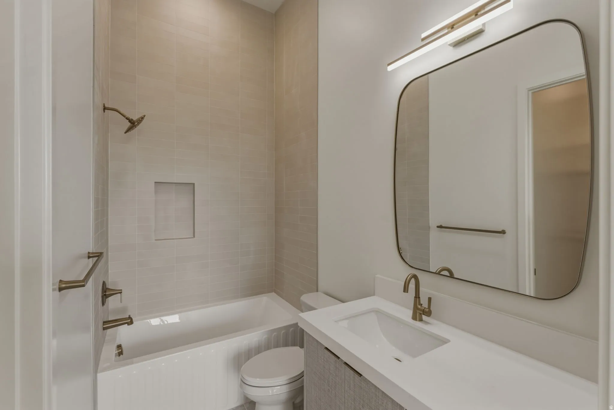 Bathroom featuring a built-in tub with a tiled surround and an integrated shower niche
