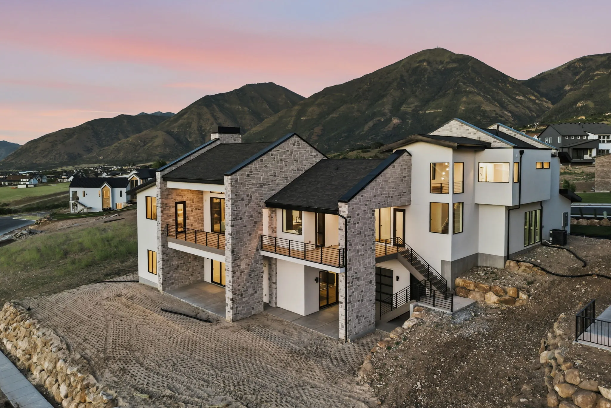 Contemporary residence featuring a multi-level design with stone facade accents and dark trim windows