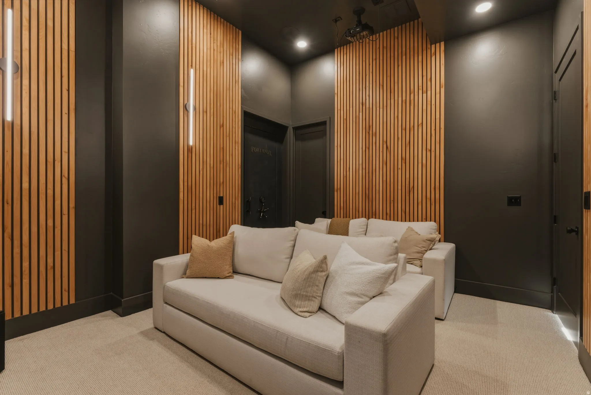 Dedicated media room featuring wood slat accent walls with integrated vertical lighting