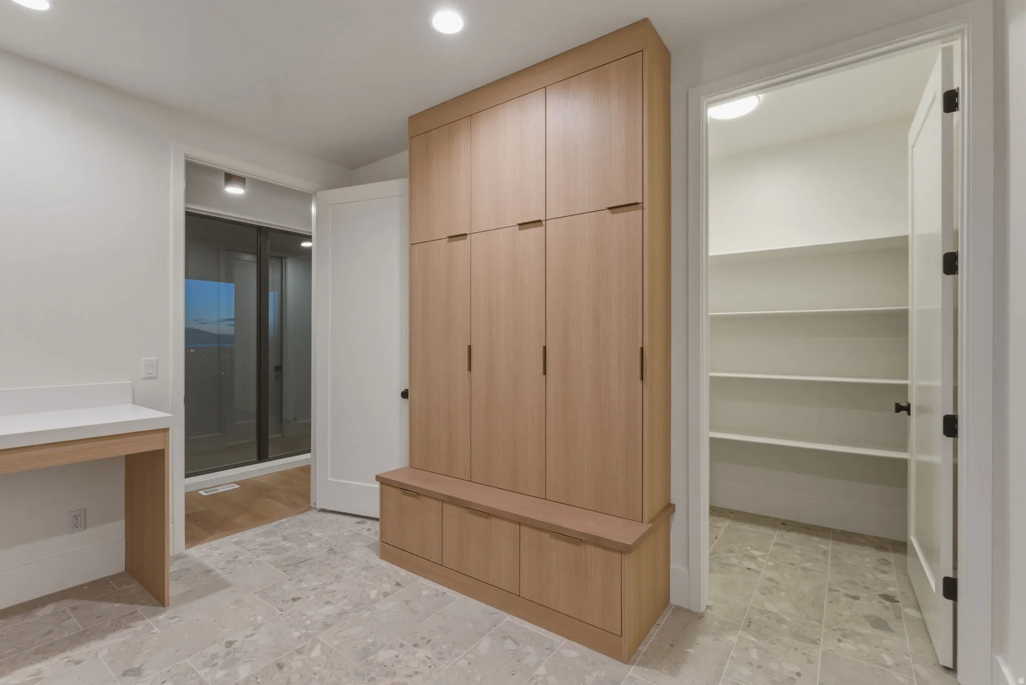 Laundry/Mud Room w/Built-in wood-finish cabinetry featuring black hardware and integrated bench seating