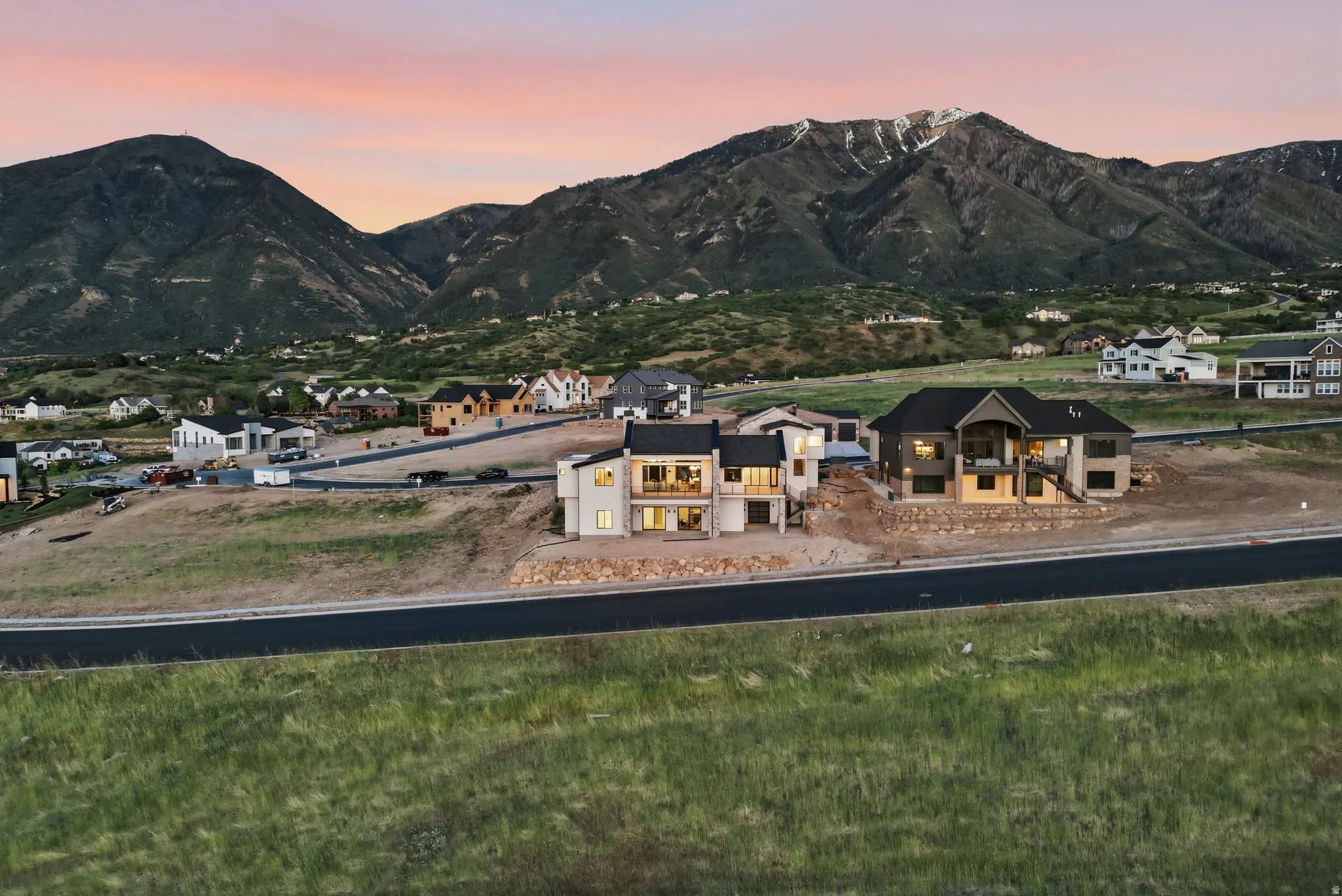 Contemporary homes under construction featuring multi-level designs and mountain backdrops