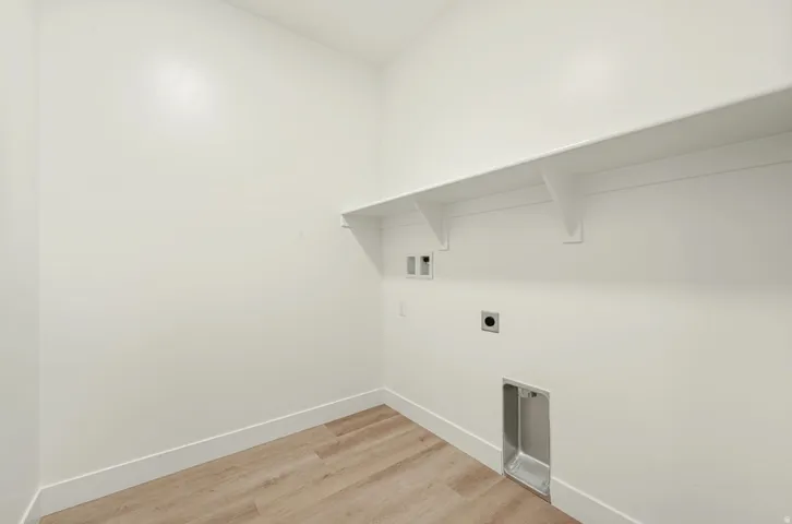 Laundry area featuring a built-in shelf, appliance hookups, and wood-finish flooring