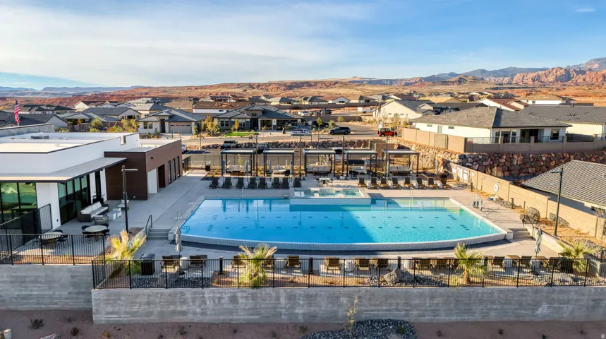 Resort-style pool area featuring a large swimming pool, integrated spa, and multiple shaded cabanas with lounge seating