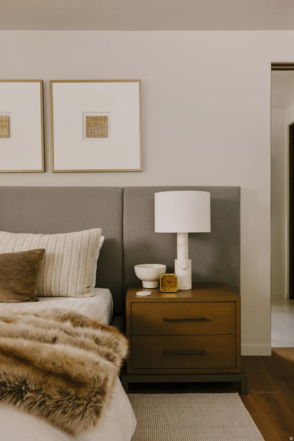Bedroom featuring a padded headboard, wood-finish nightstand with two drawers, and a rug