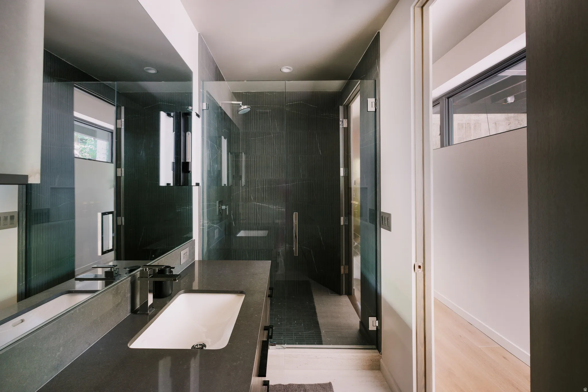 Modern bathroom featuring a dark stone-finish vanity with an integrated rectangular sink and a wall-mounted faucet