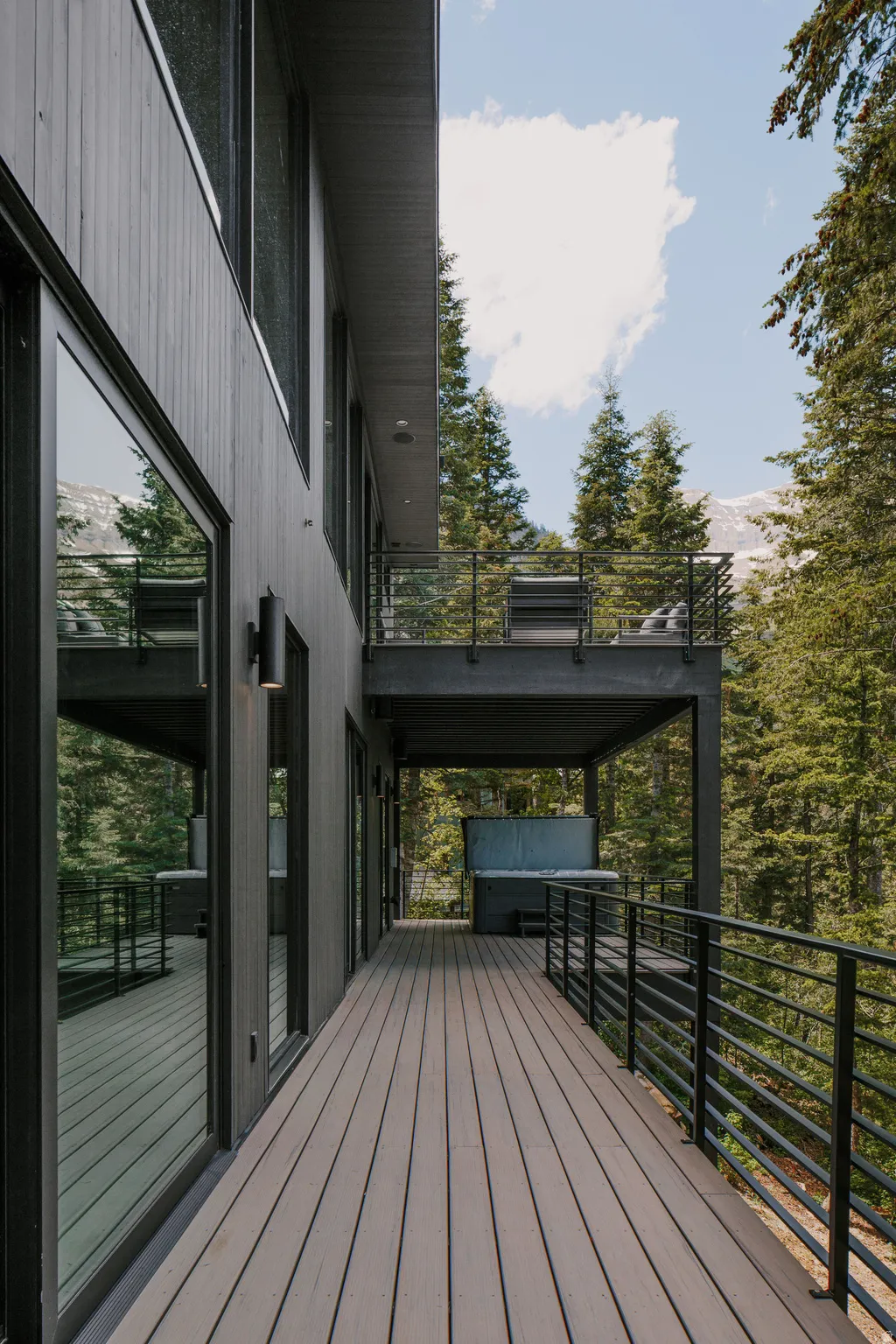Expansive decking with composite boards featuring black metal railings and a built-in spa