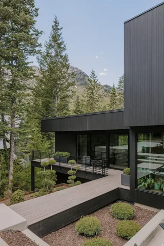 Modern exterior featuring dark vertical siding and a multi-level deck