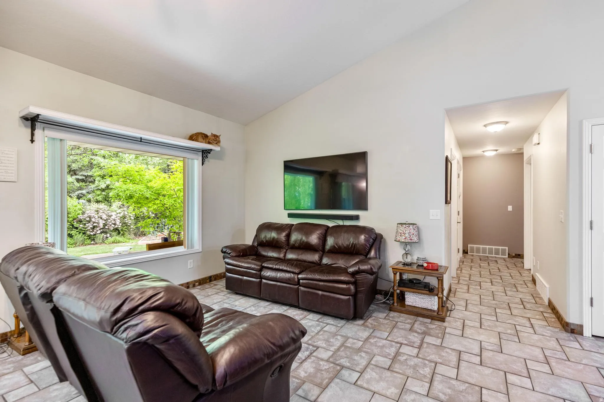 Living area with vaulted ceiling and large picture window