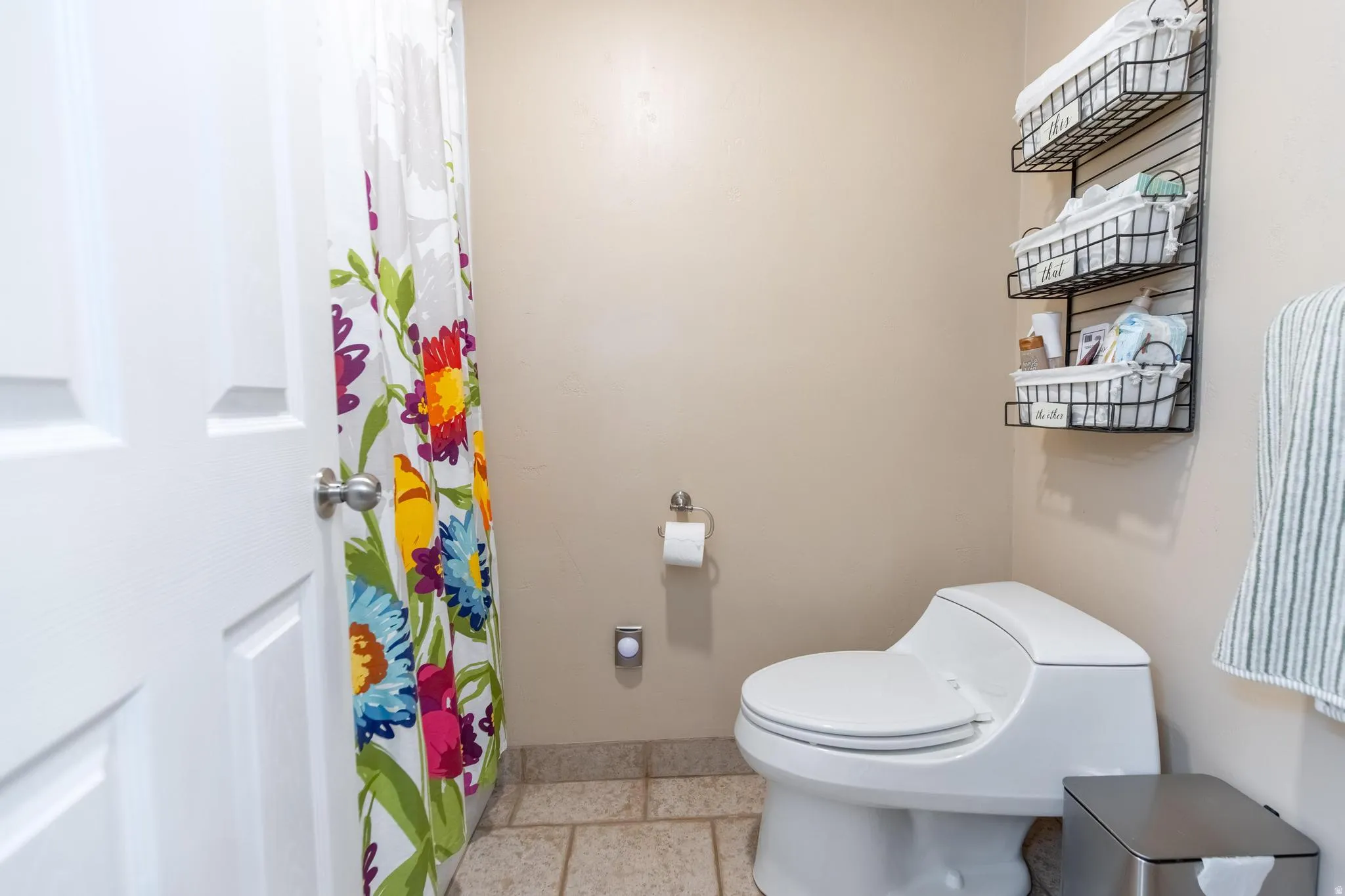 Full bathroom featuring a white two-panel door, neutral wall paint, and tiled flooring