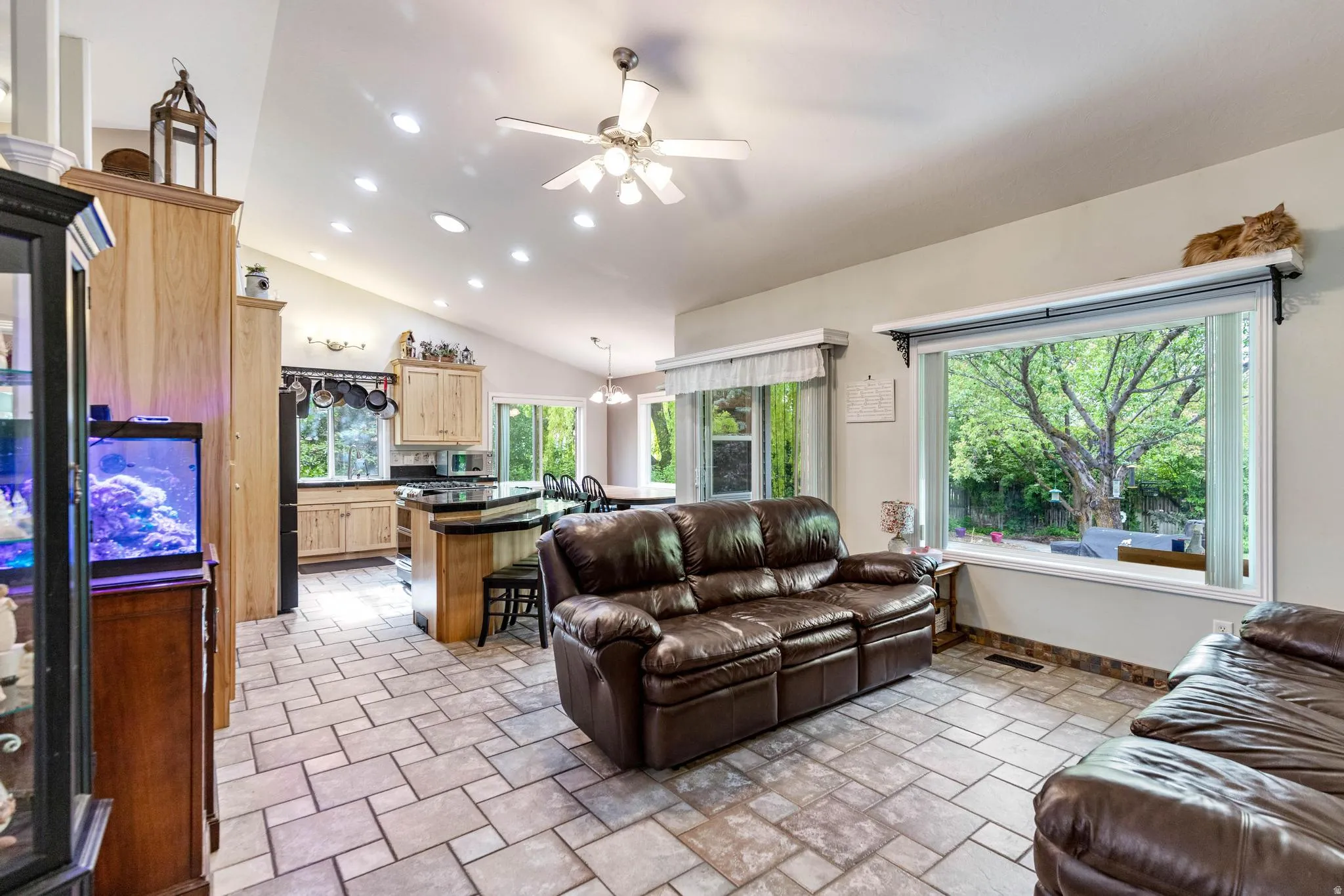 Open-concept living space featuring vaulted ceilings, recessed lighting, and a ceiling fan
