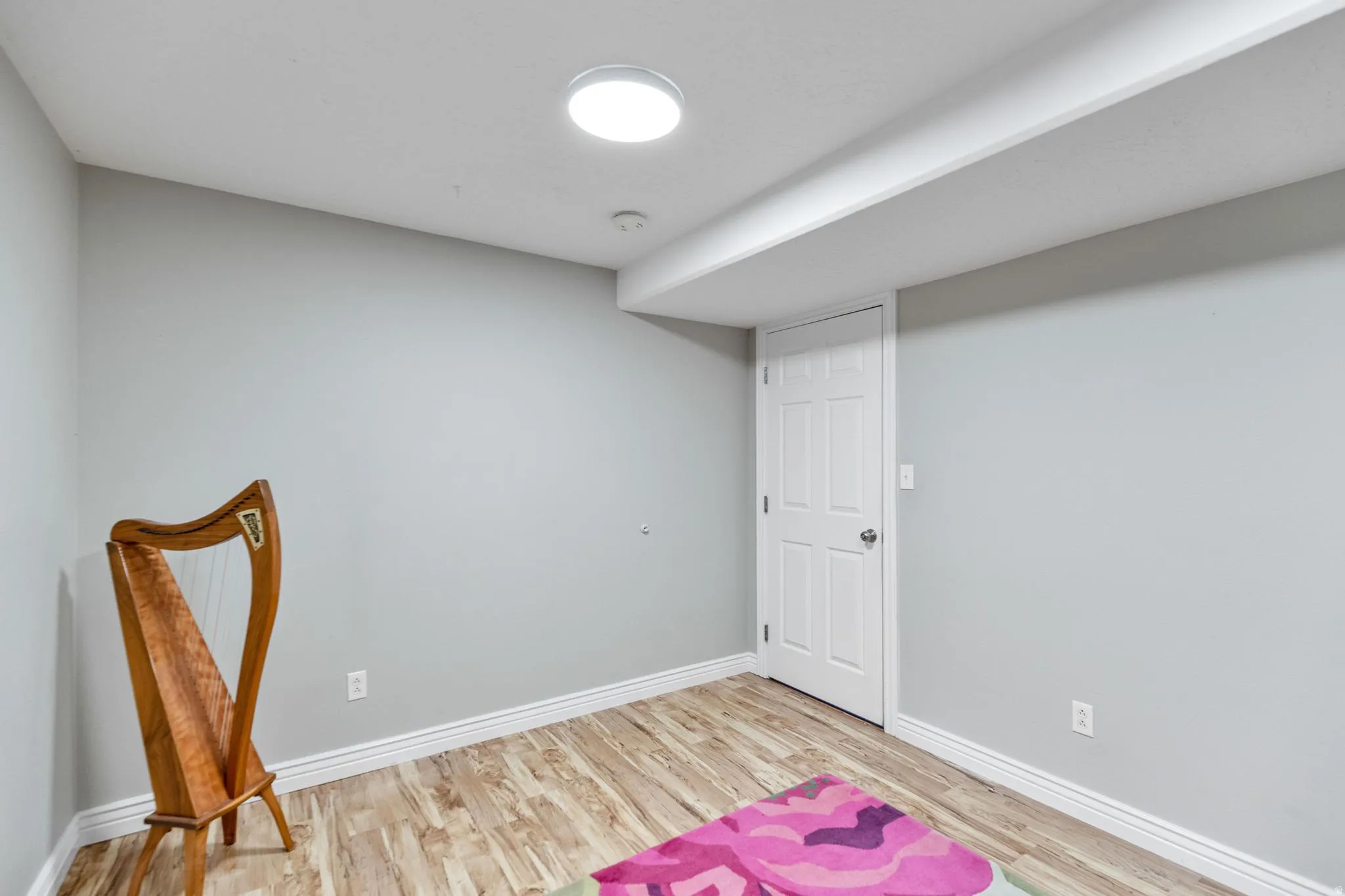 Room featuring wood-finish flooring, light grey walls, and a recessed ceiling light fixture