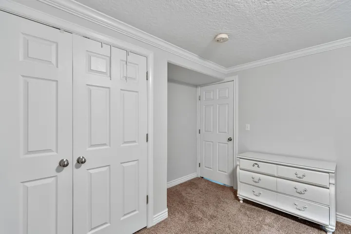 Room featuring a textured ceiling, neutral wall paint, and brown carpet flooring