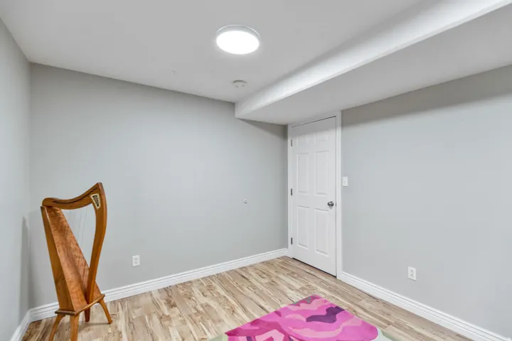 Room featuring wood-finish flooring, light grey walls, and a recessed ceiling light fixture