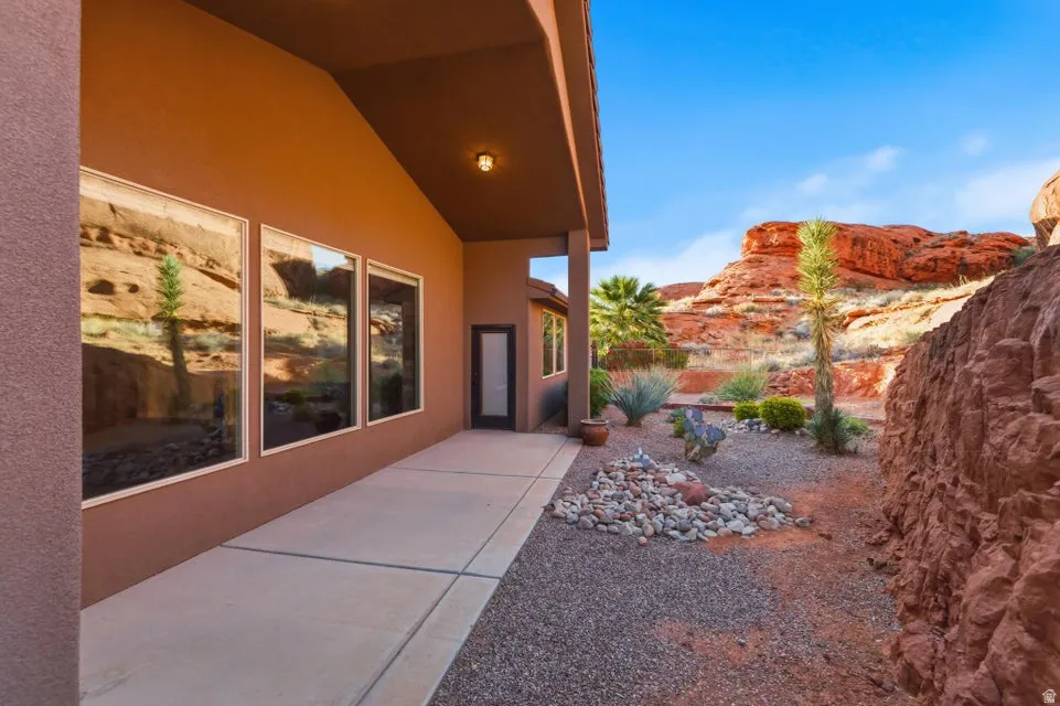 Terracotta-toned exterior featuring a covered patio with recessed lighting and three large windows