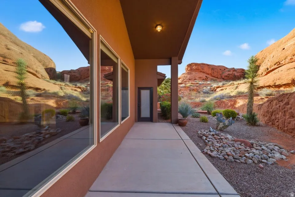 Stucco exterior with a covered patio and concrete walkway