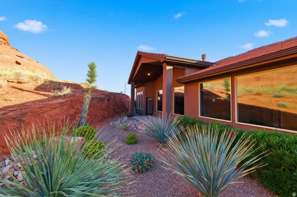 Southwest-style residence featuring a red tile roof and a stucco exterior