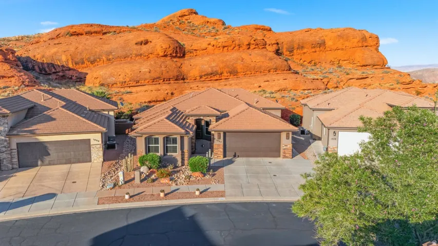 Contemporary stucco home with a tile roof, integrated two-car garage, and desert-adapted landscaping