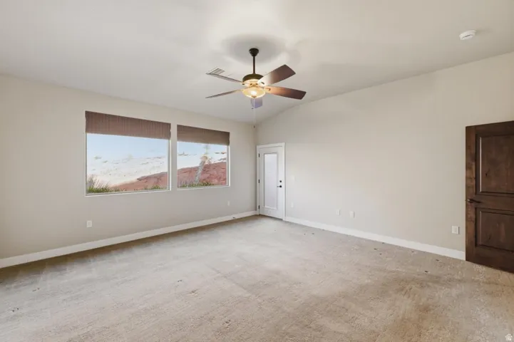 Spacious room featuring vaulted ceilings, recessed lighting, and a ceiling fan