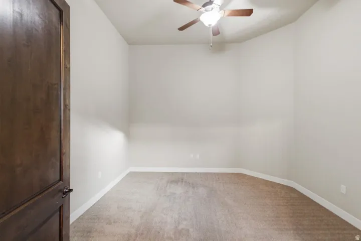 Expansive interior space featuring light-colored walls and plush carpeting