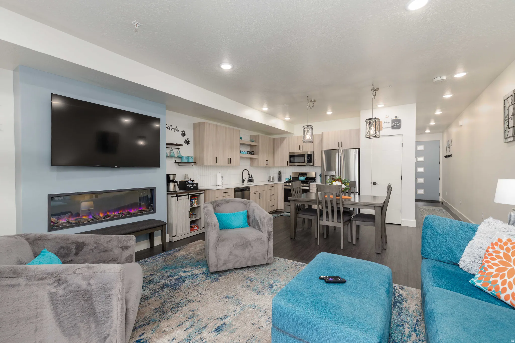 Open-concept living space featuring an electric fireplace and recessed lighting