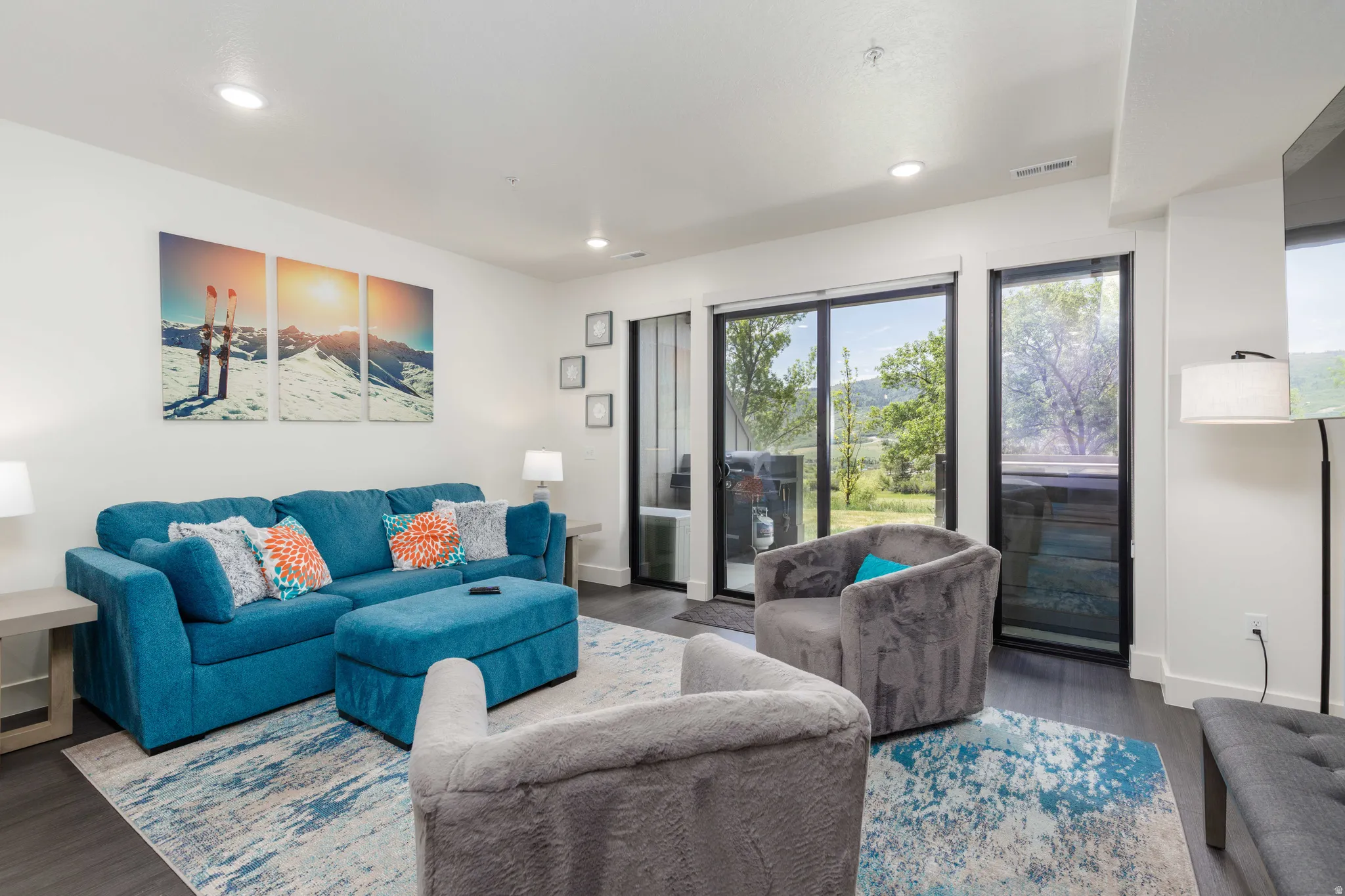 Living area featuring dark wood-finish flooring, recessed lighting, and white baseboards