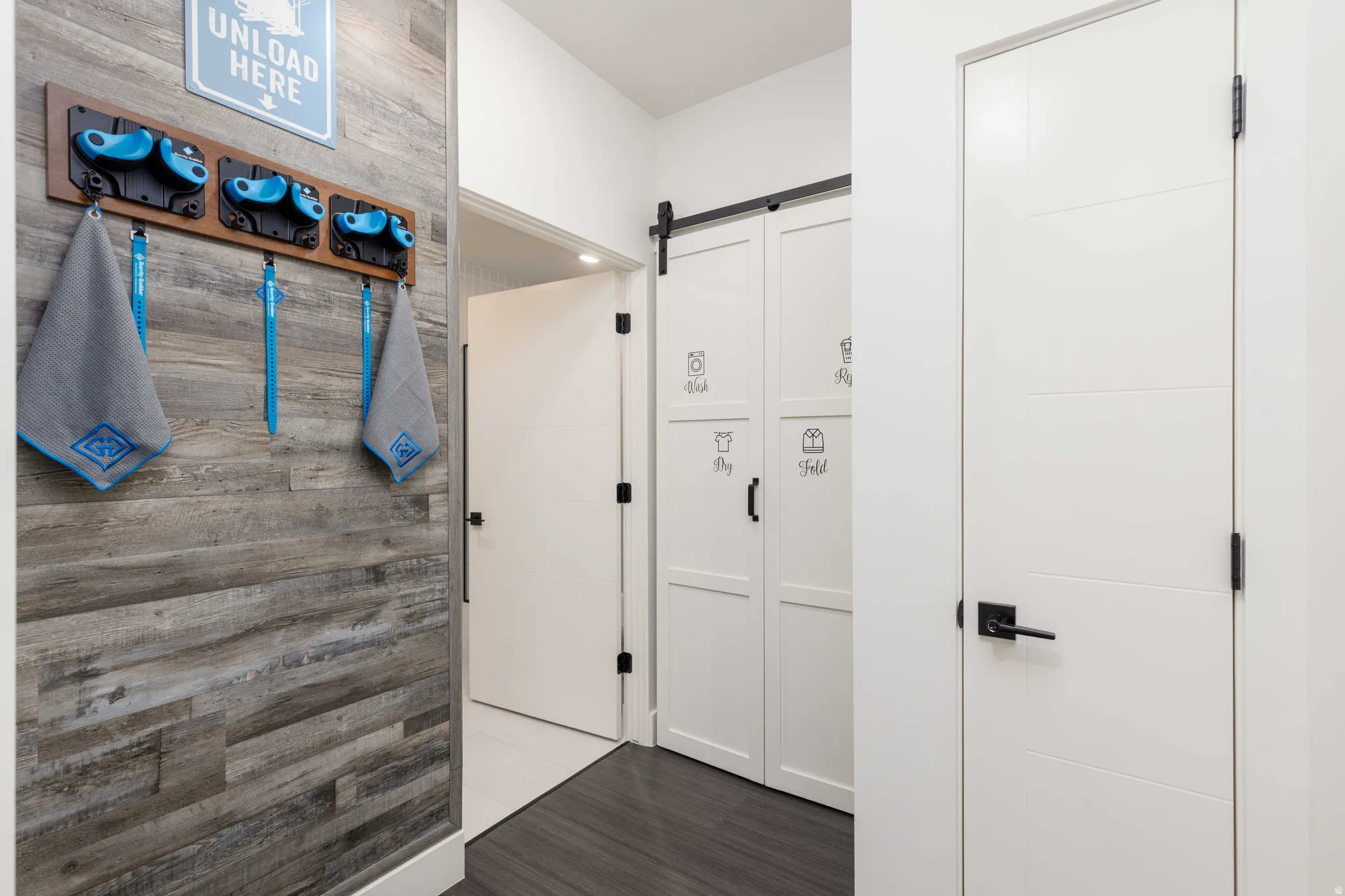 Wall paneling featuring a weathered wood-finish, complemented by sleek white doors with dark hardware