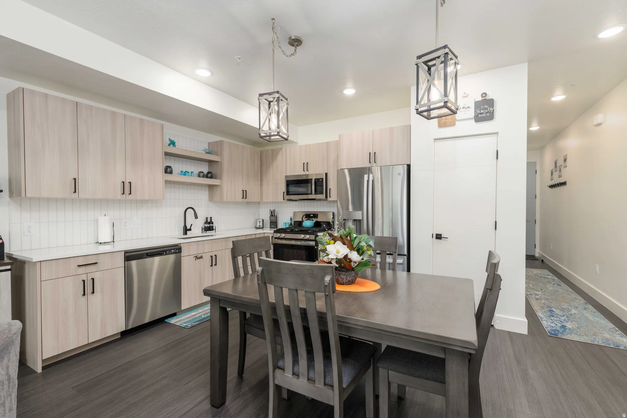Modern kitchen featuring light wood-finish cabinetry and stainless steel appliances